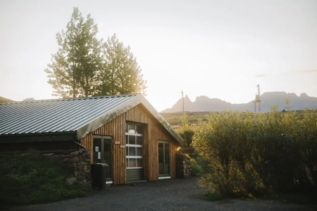 Fossardalur Campsite building at sunset with mountains