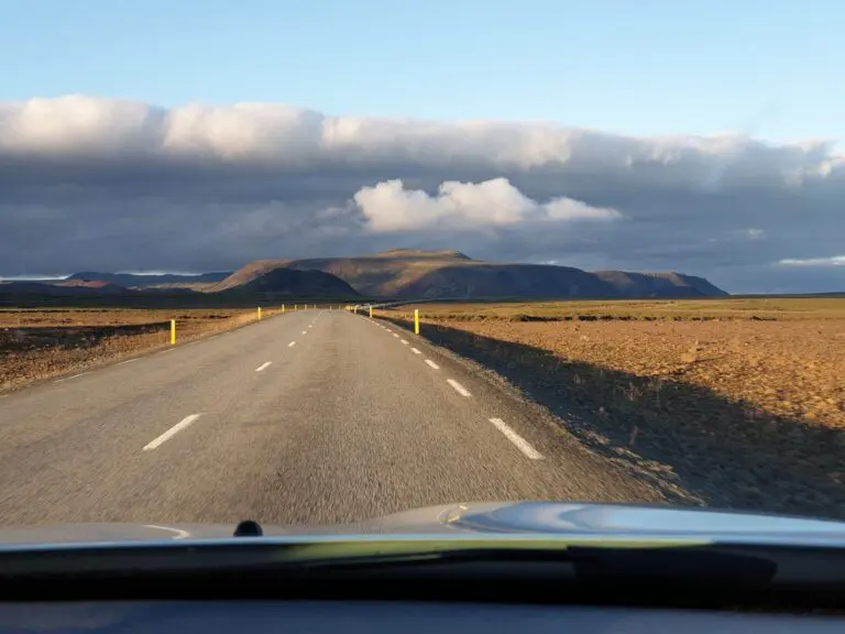 empty road through Icelandic landscape under dramatic sky