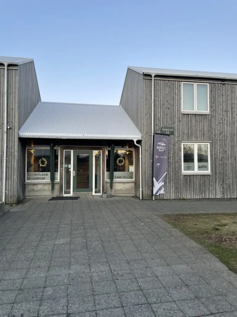 exterior of a wooden building with a sign for Lava Hostel