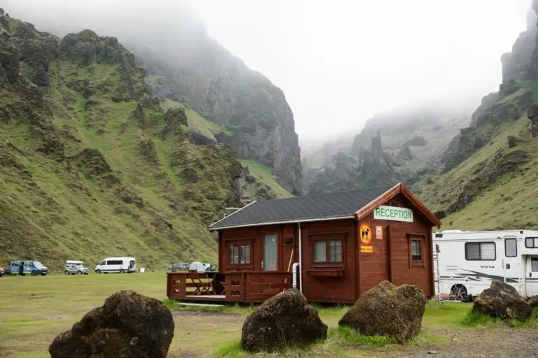 wooden reception cabin at a campsite in a misty green canyon