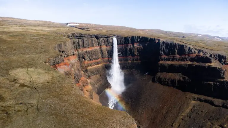 Hengifoss waterfall with rainbow in Iceland's dramatic landscape