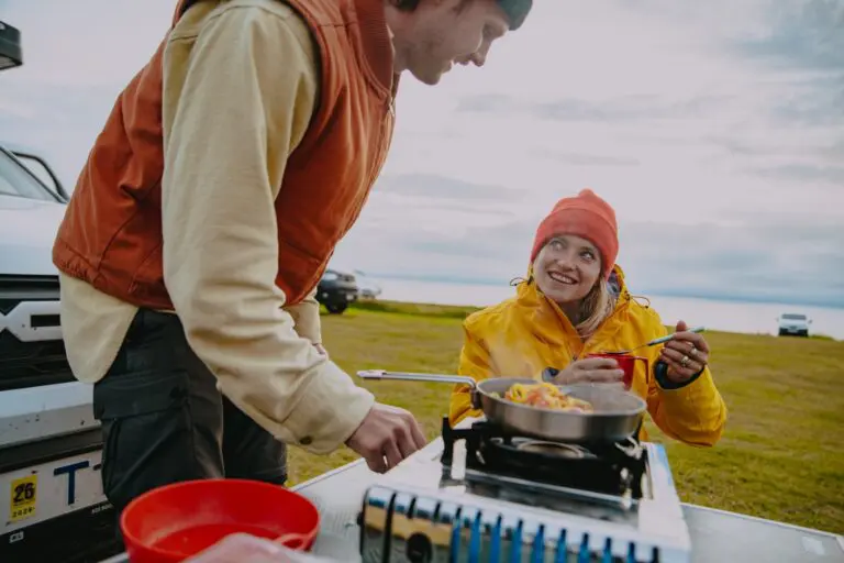couple cooking pasta on camping stove in Iceland