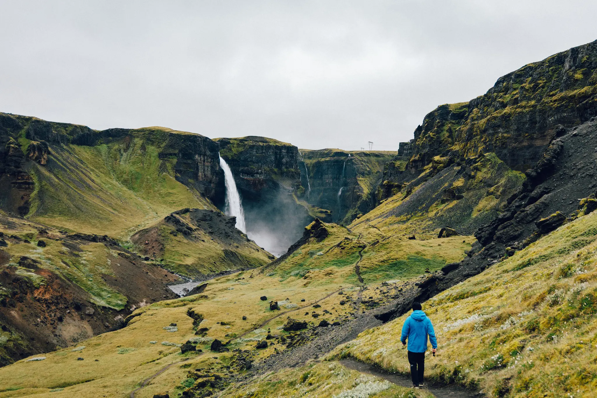 hiker walking towards Haifoss waterfall in Iceland