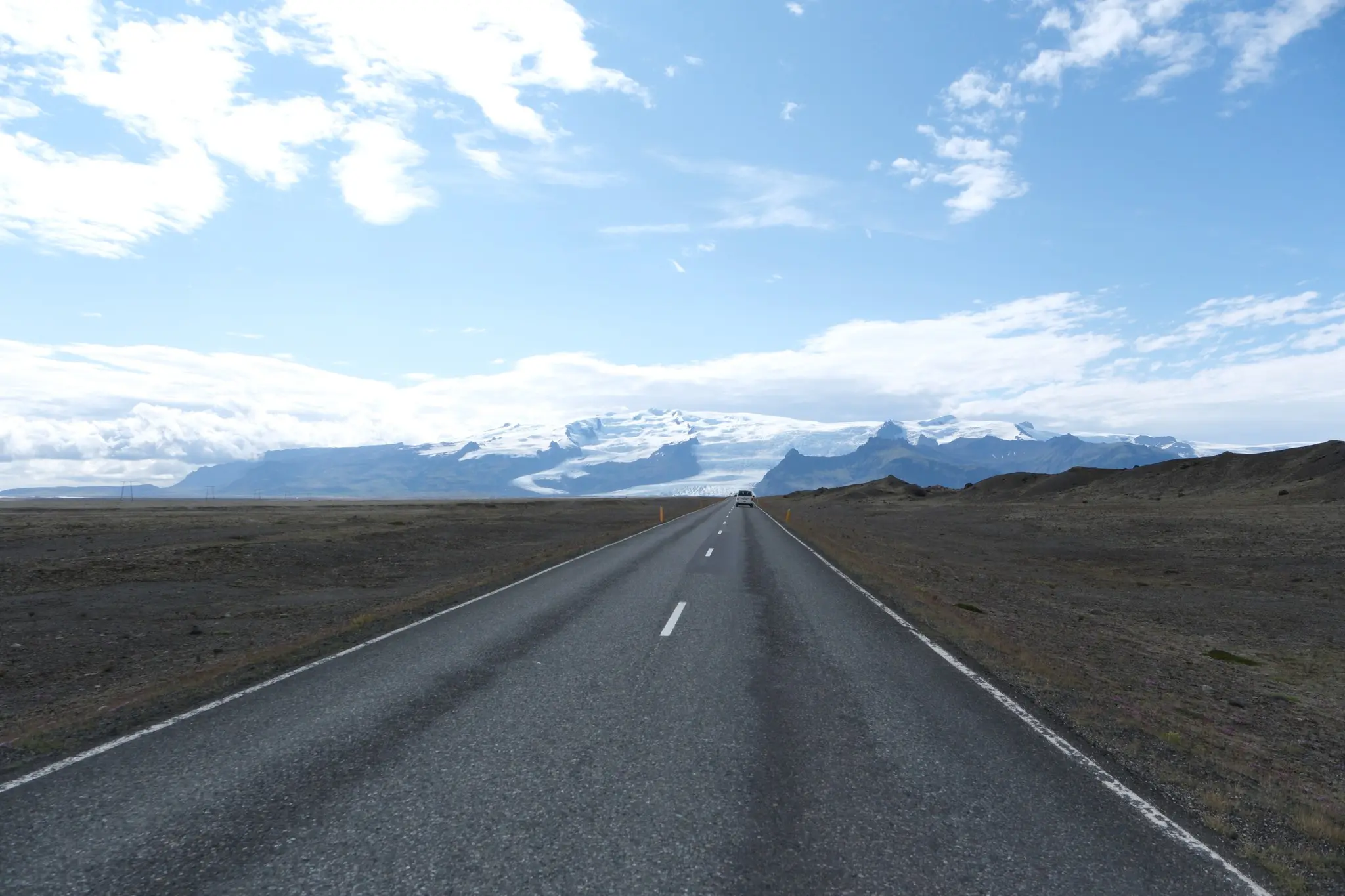 long road leading to snow-capped mountains in Iceland