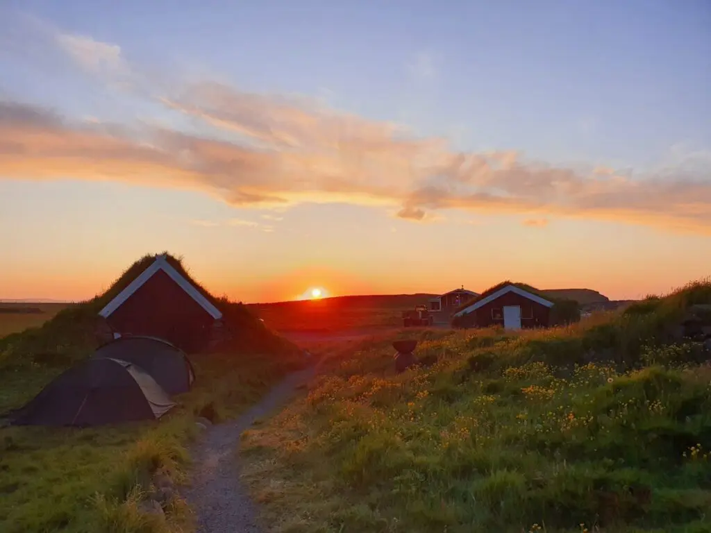 sunset over turf houses and tents in Iceland